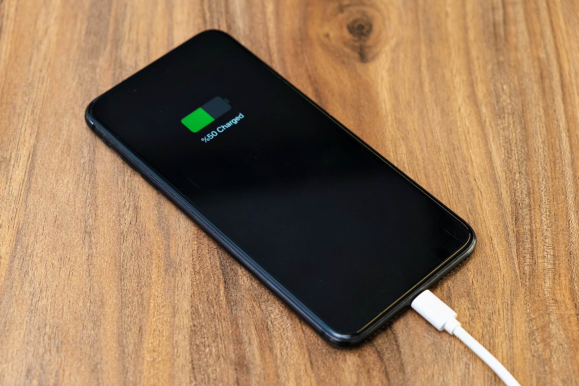 smartphone battery charging showing half charged battery on fast cable charger concept